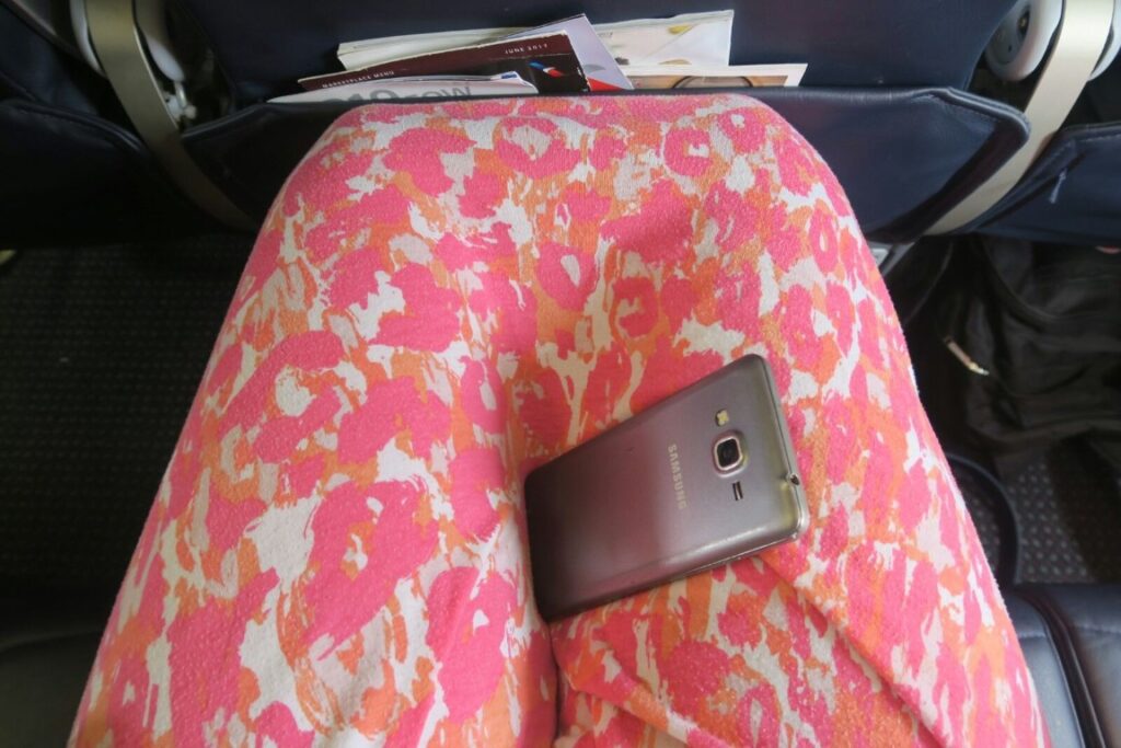 Legs touching the seat in front of woman on an airplane