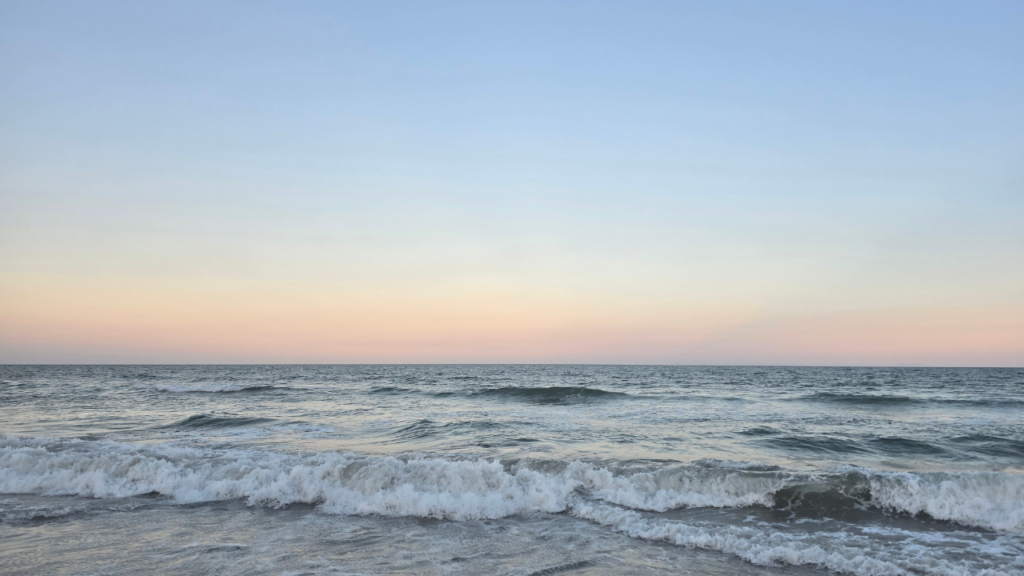 10 Simple Beach Activities That Don’t Require Extra Supplies listening to the waves and the sound of the ocean. Picture of a sunset over the beach.