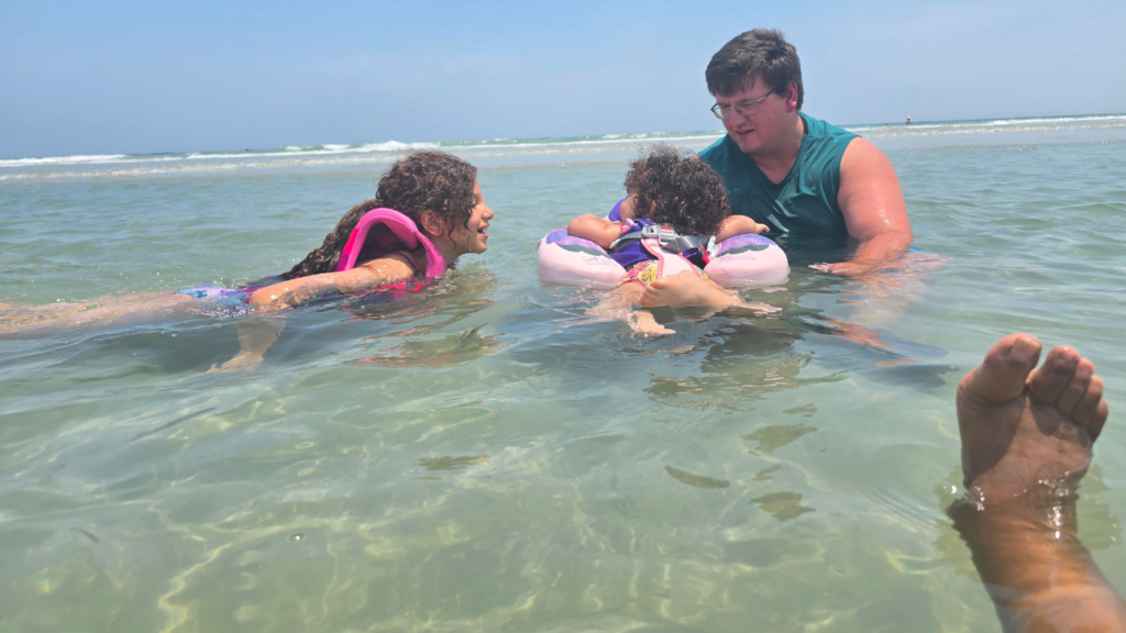 Biracial family of 4 playing in the tide pool simply having fun together